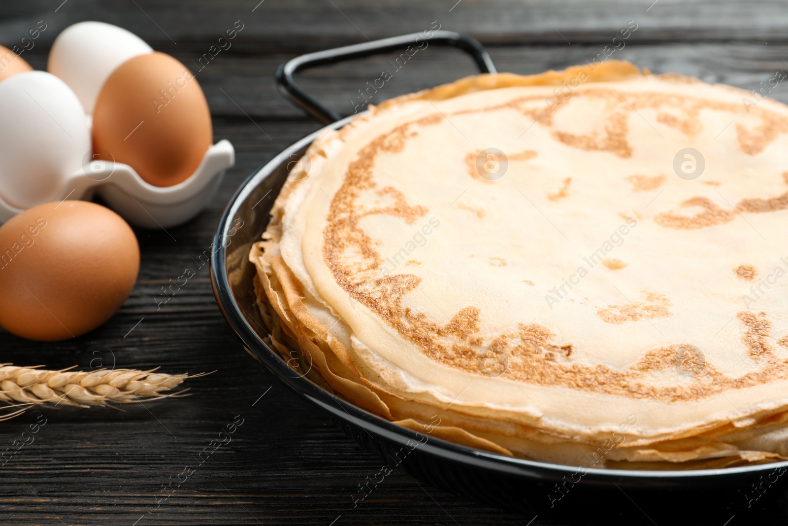 Photo of Dish with thin pancakes on kitchen table