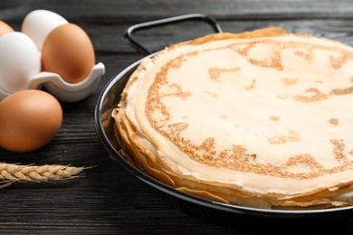 Dish with thin pancakes on kitchen table