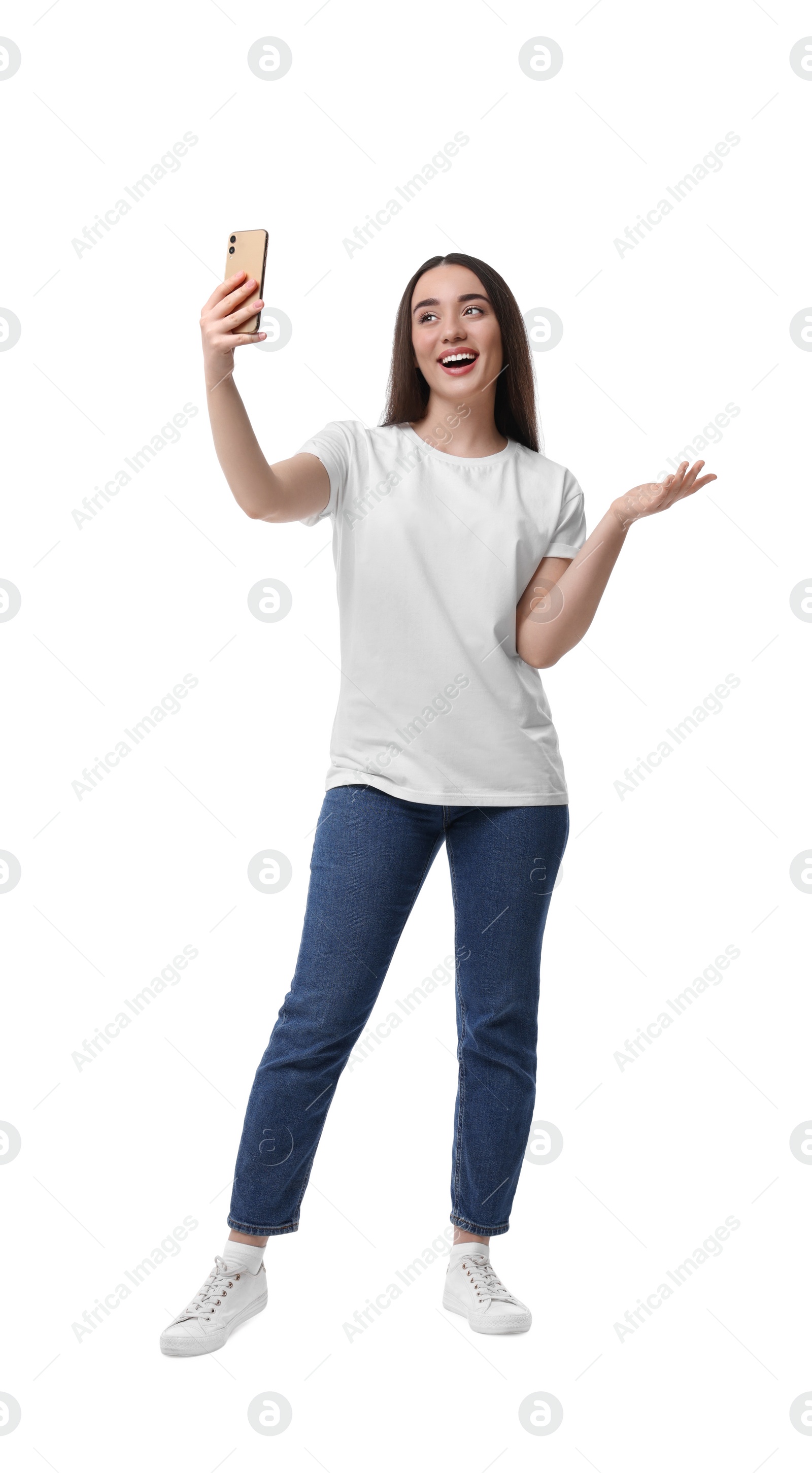 Photo of Smiling young woman taking selfie with smartphone on white background