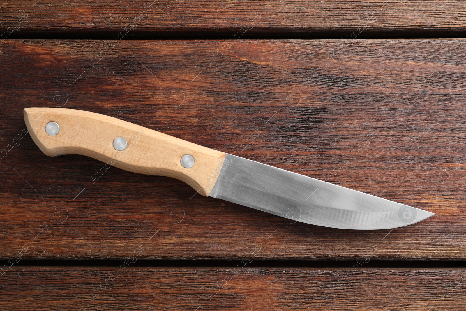 Photo of One sharp knife on wooden table, top view