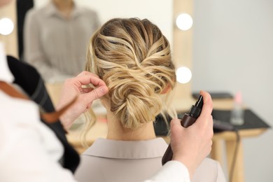 Hair styling. Professional hairdresser working with client indoors, closeup