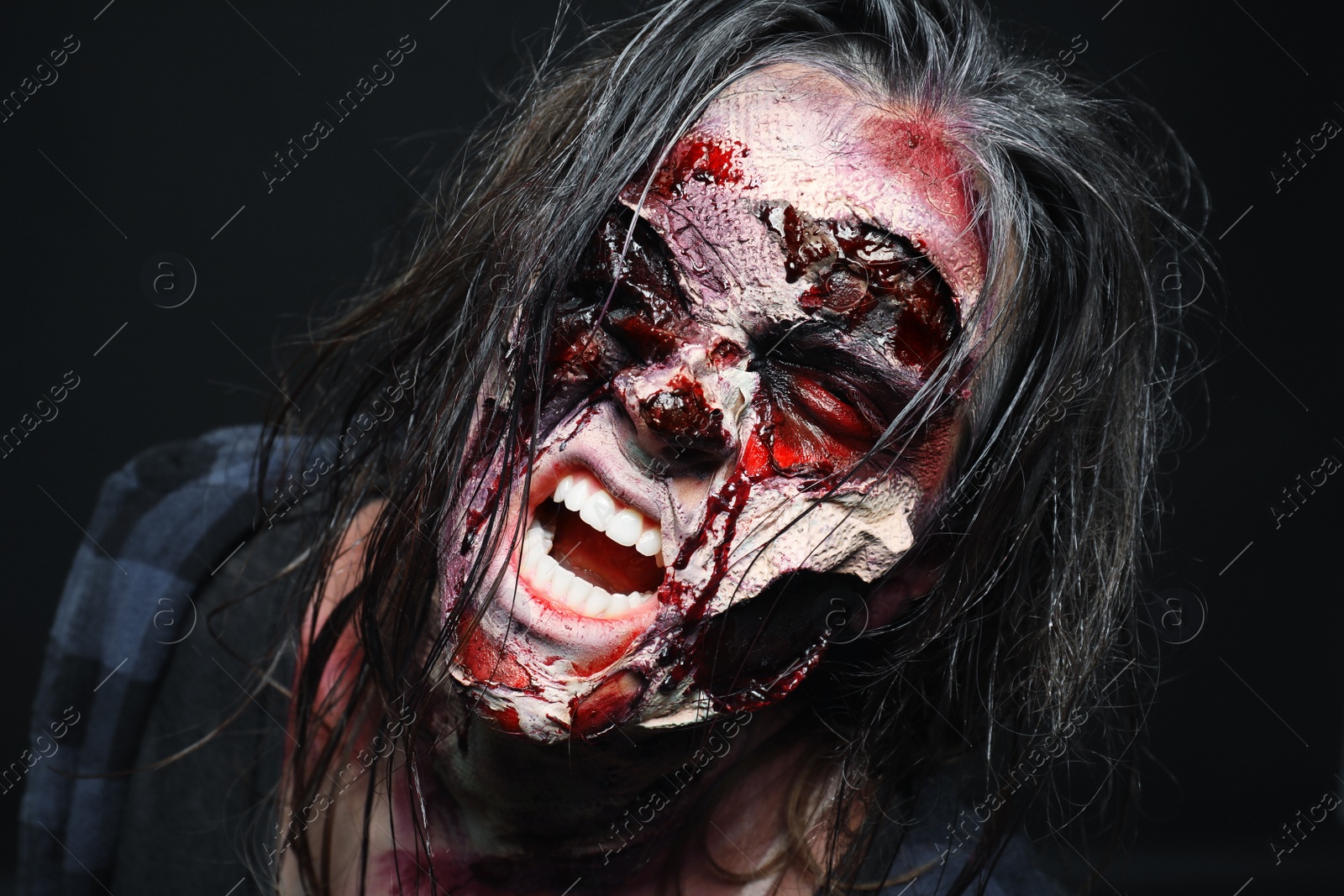 Photo of Scary zombie on dark background, closeup. Halloween monster