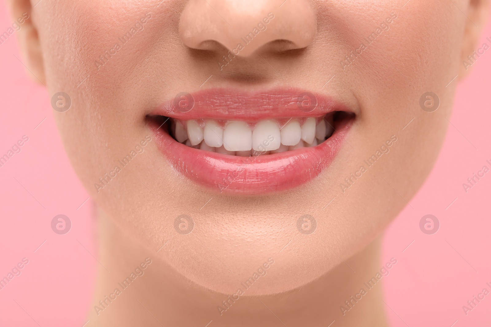 Photo of Woman with clean teeth smiling on pink background, closeup