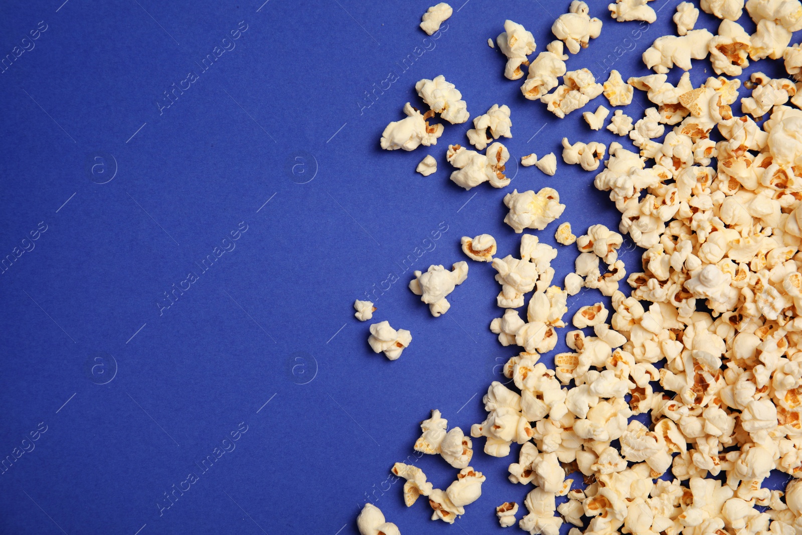 Photo of Tasty fresh popcorn on color background, top view