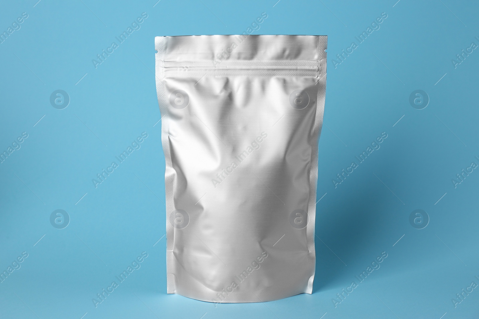 Photo of One blank foil package on light blue background