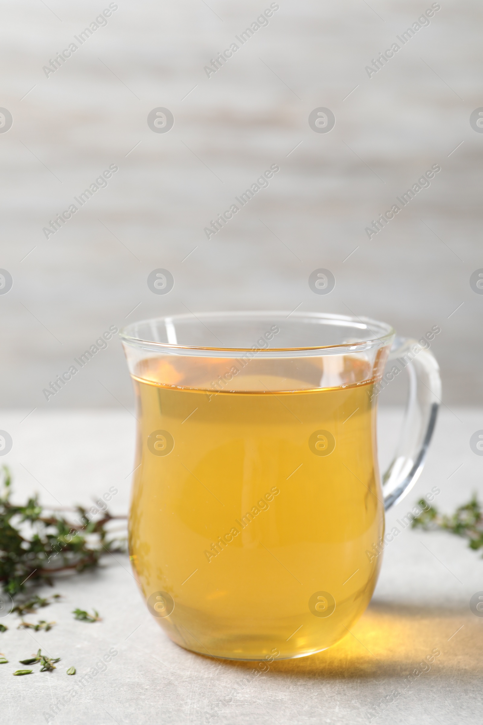 Photo of Aromatic herbal tea with thyme on light table
