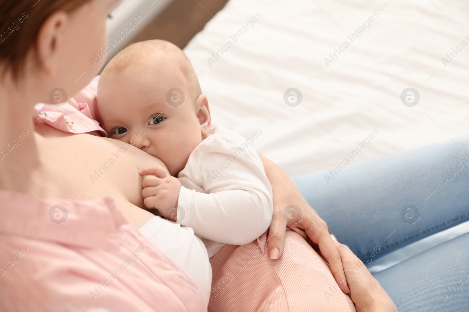 Photo of Young woman breast feeding her little baby, closeup