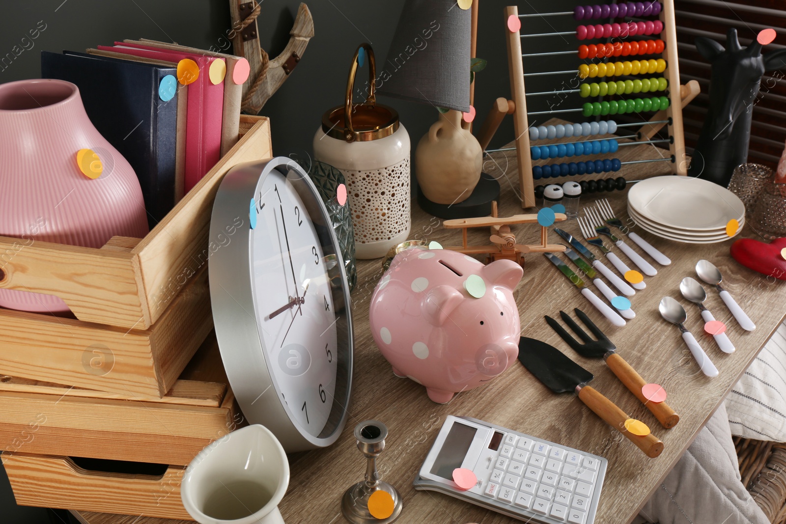 Photo of Many different items on wooden table indoors. Garage sale