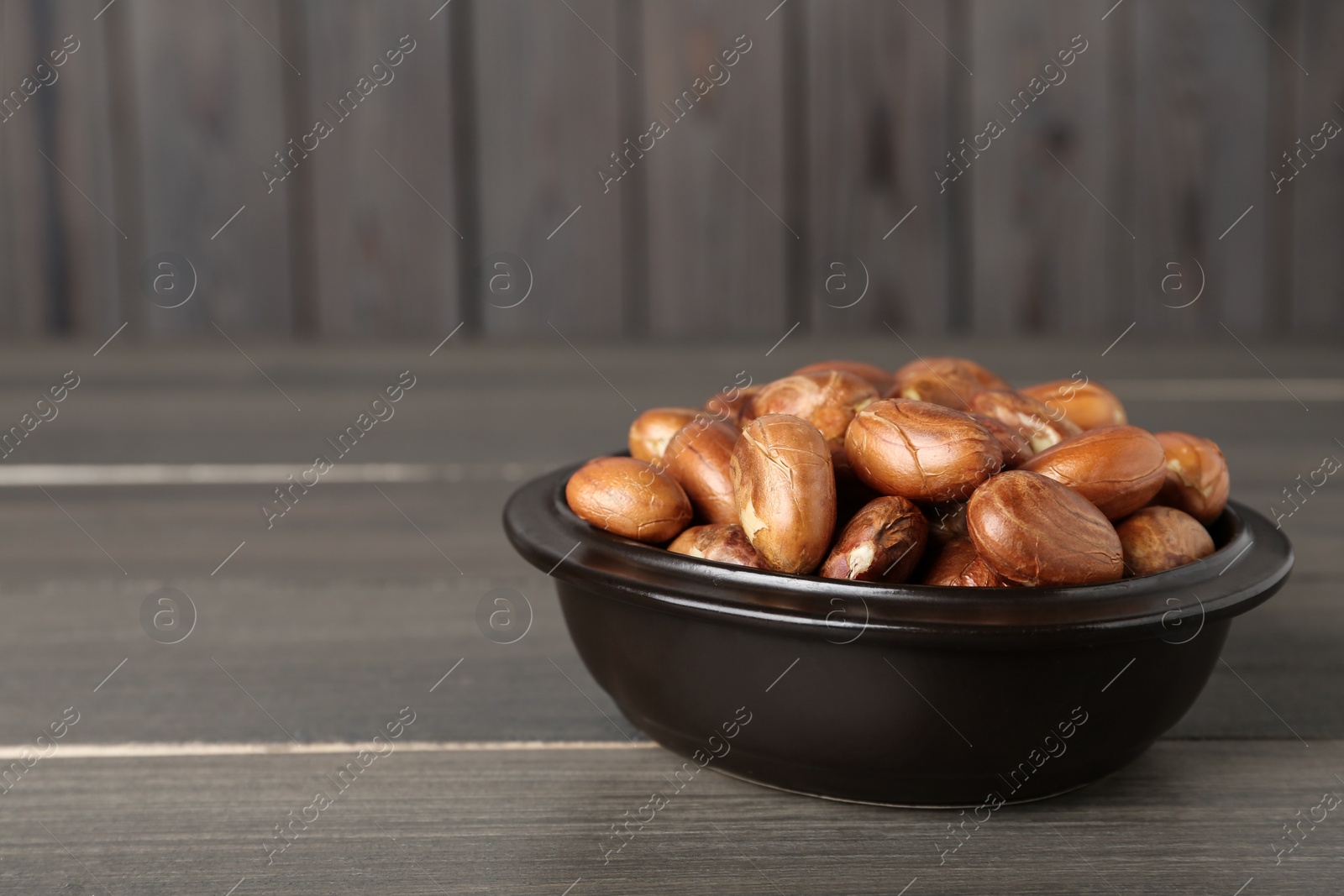 Photo of Bowl of jackfruit seeds on wooden table. Space for text