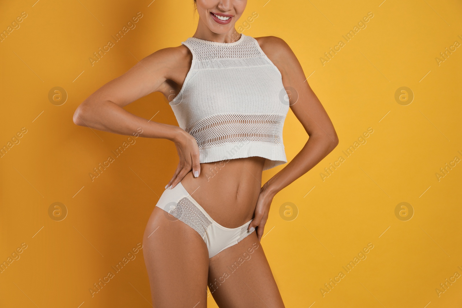 Photo of Woman in white sexy panties on yellow background, closeup