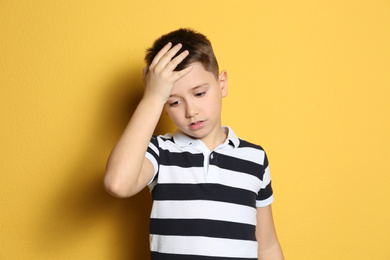 Portrait of emotional preteen boy on yellow background