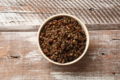 Photo of Delicious lentils in bowl on wooden table, top view