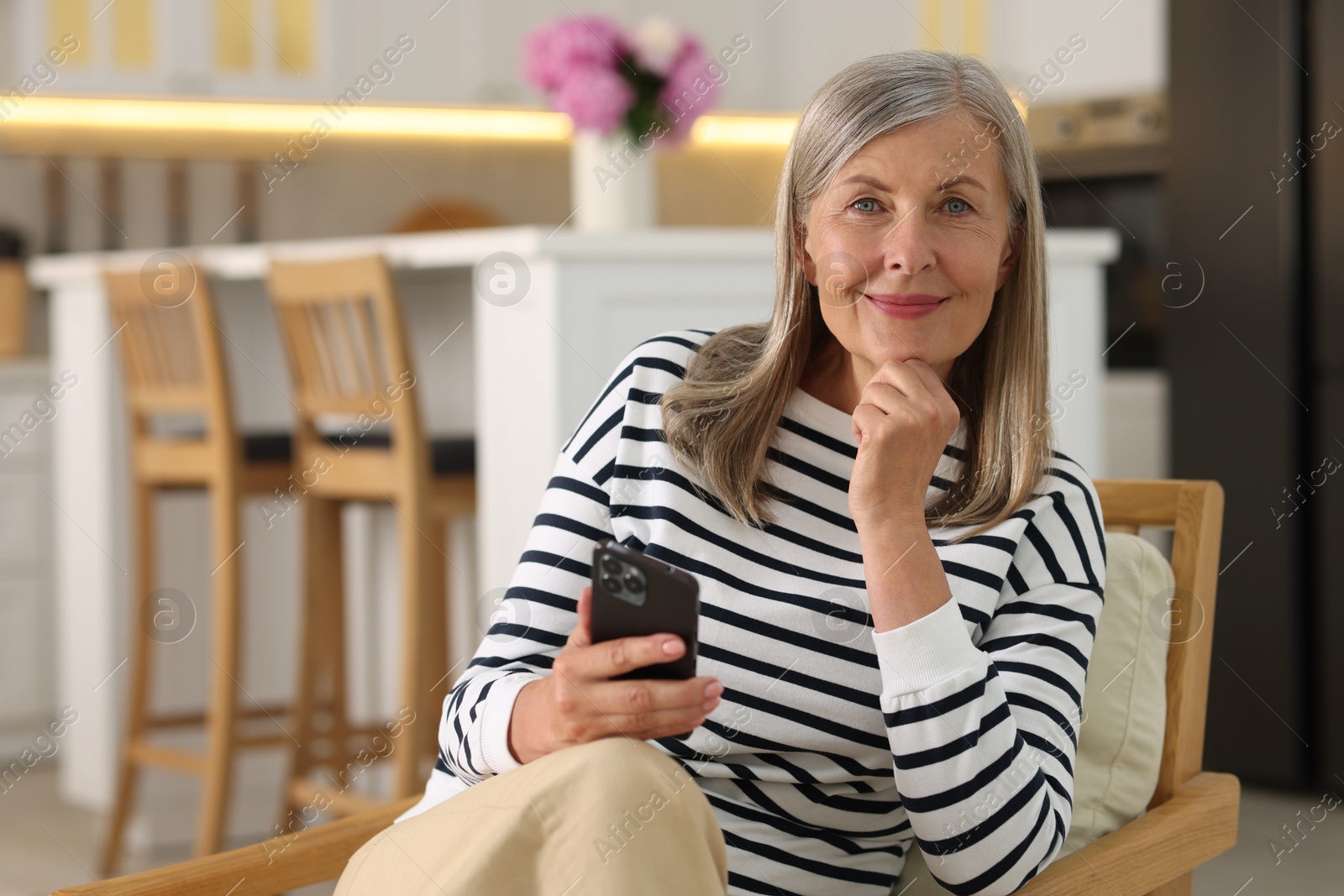 Photo of Senior woman using mobile phone at home, space for text