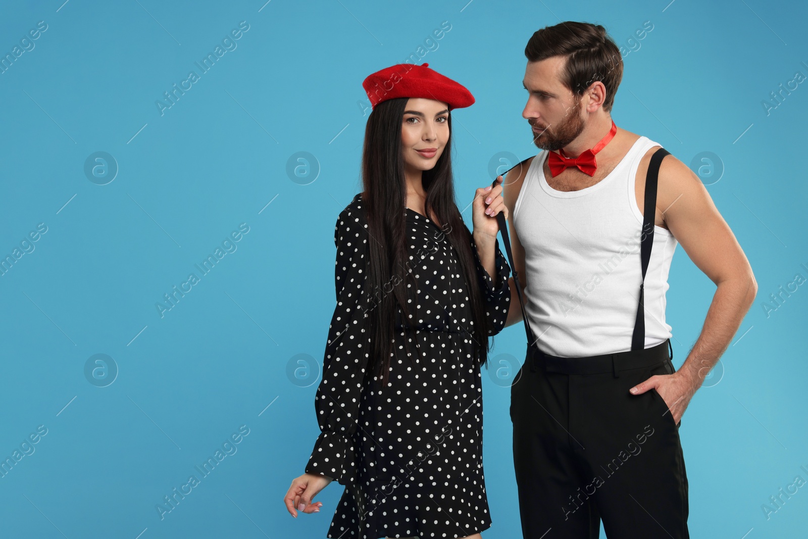 Photo of Beautiful couple posing together on light blue background, space for text