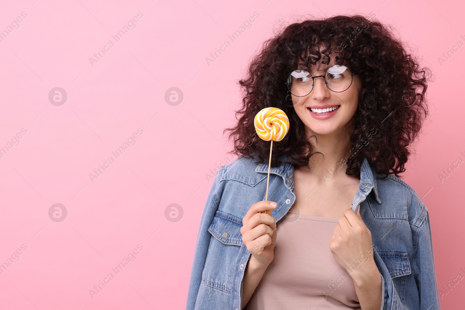 Photo of Beautiful woman with lollipop on pink background, space for text