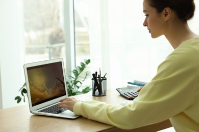 Photo of Woman working with laptop in office. Forex trading