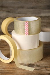 Photo of Many rolls of adhesive tape on wooden table
