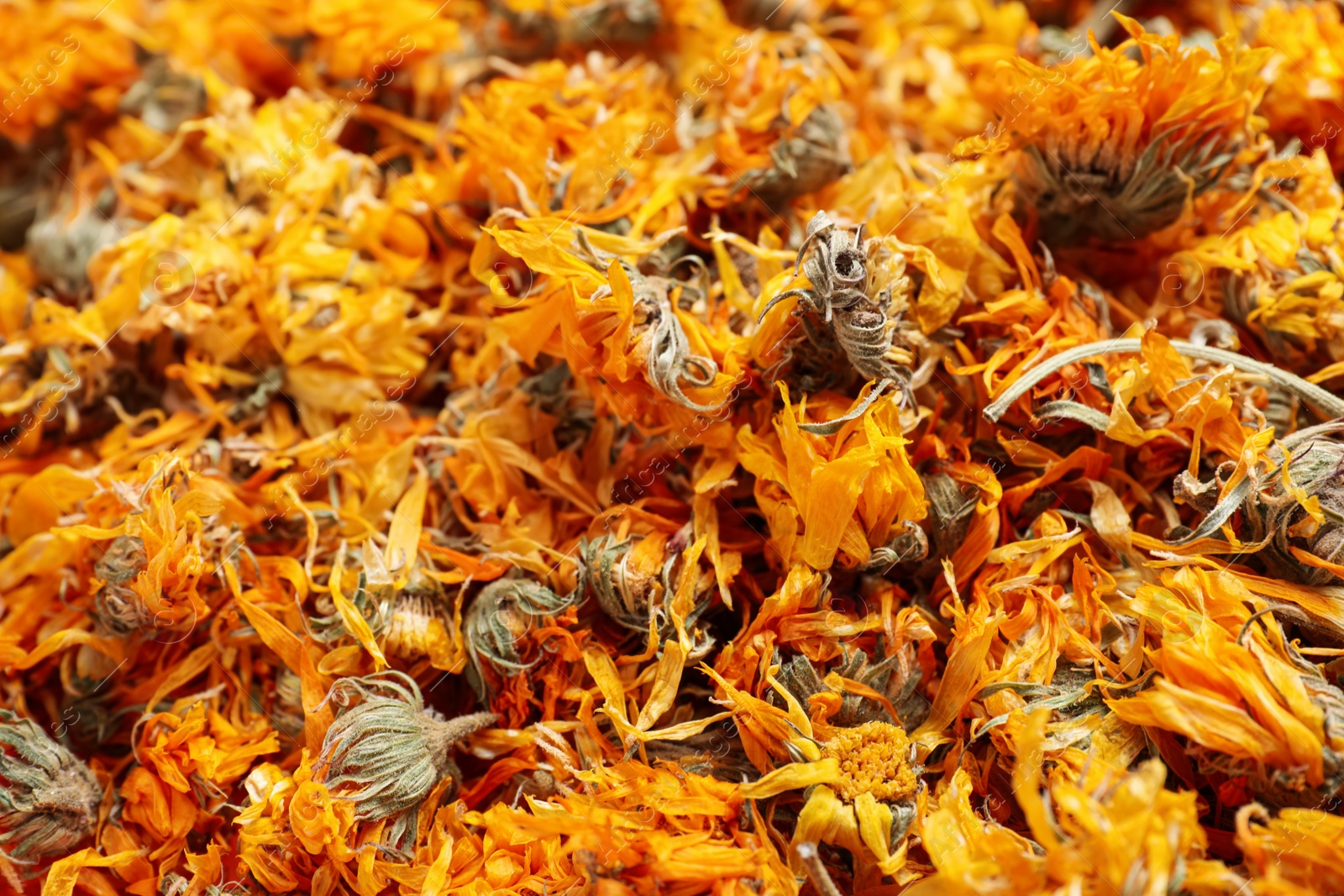 Photo of Pile of dry calendula flowers as background, closeup