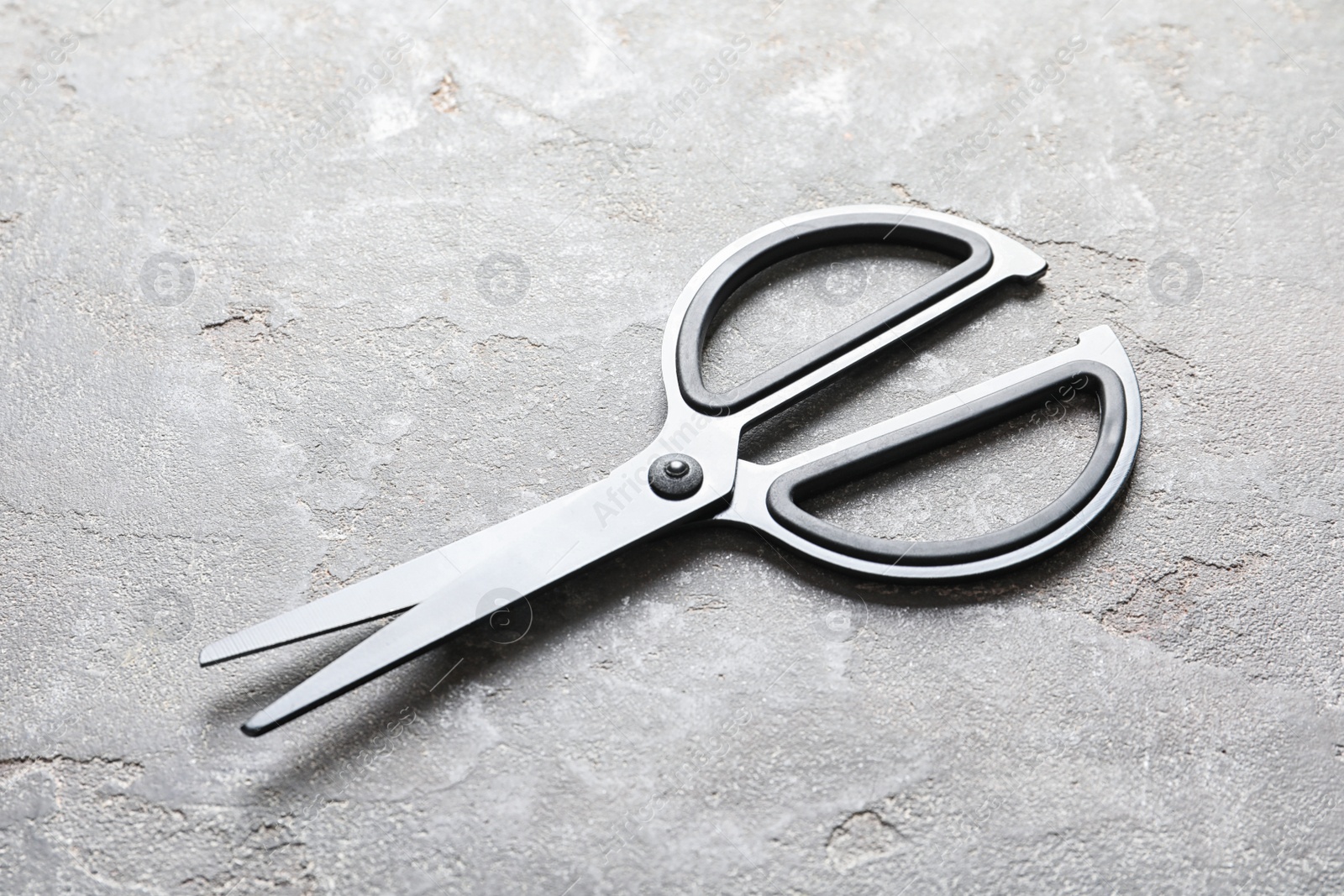 Photo of Scissors on grey stone background. Tailoring equipment