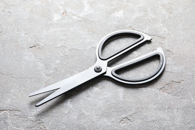 Scissors on grey stone background. Tailoring equipment