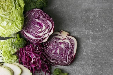 Different types of cut cabbage on grey table, flat lay. Space for text