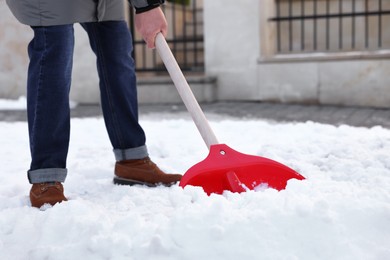 Man removing snow with shovel outdoors, closeup
