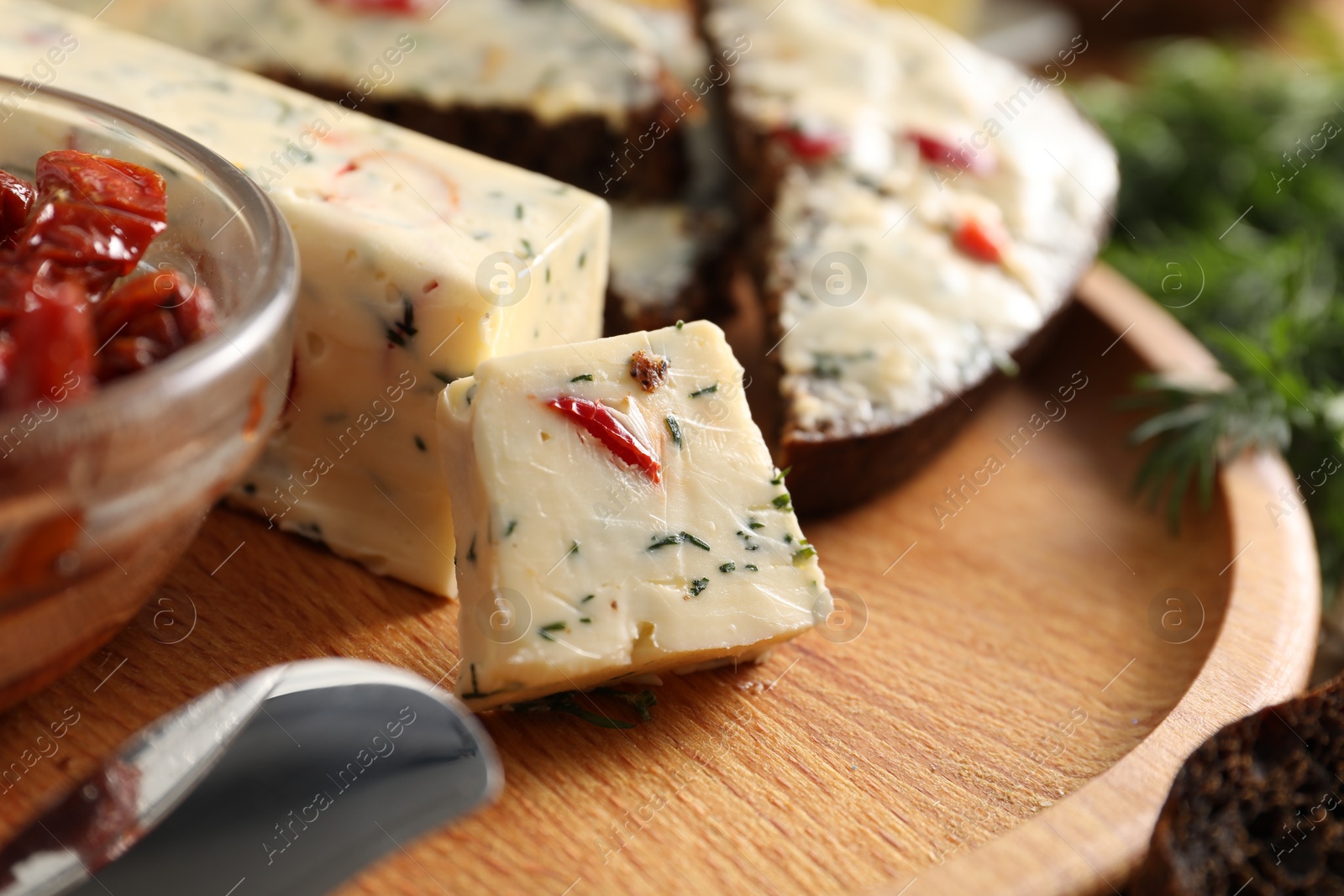 Photo of Tasty butter with dill and chili pepper on wooden plate, closeup