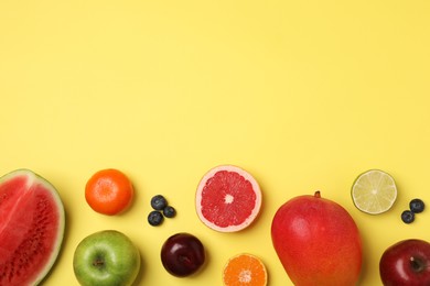 Photo of Different ripe fruits on yellow background, flat lay. Space for text