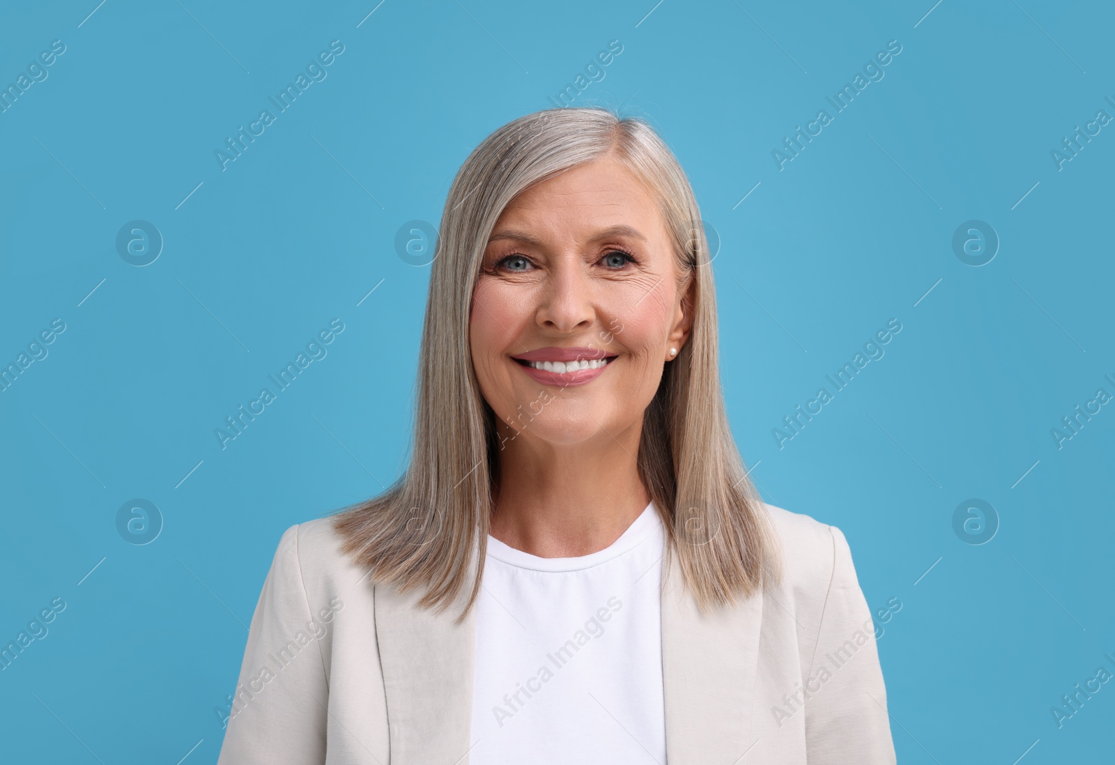 Photo of Portrait of beautiful middle aged woman on light blue background