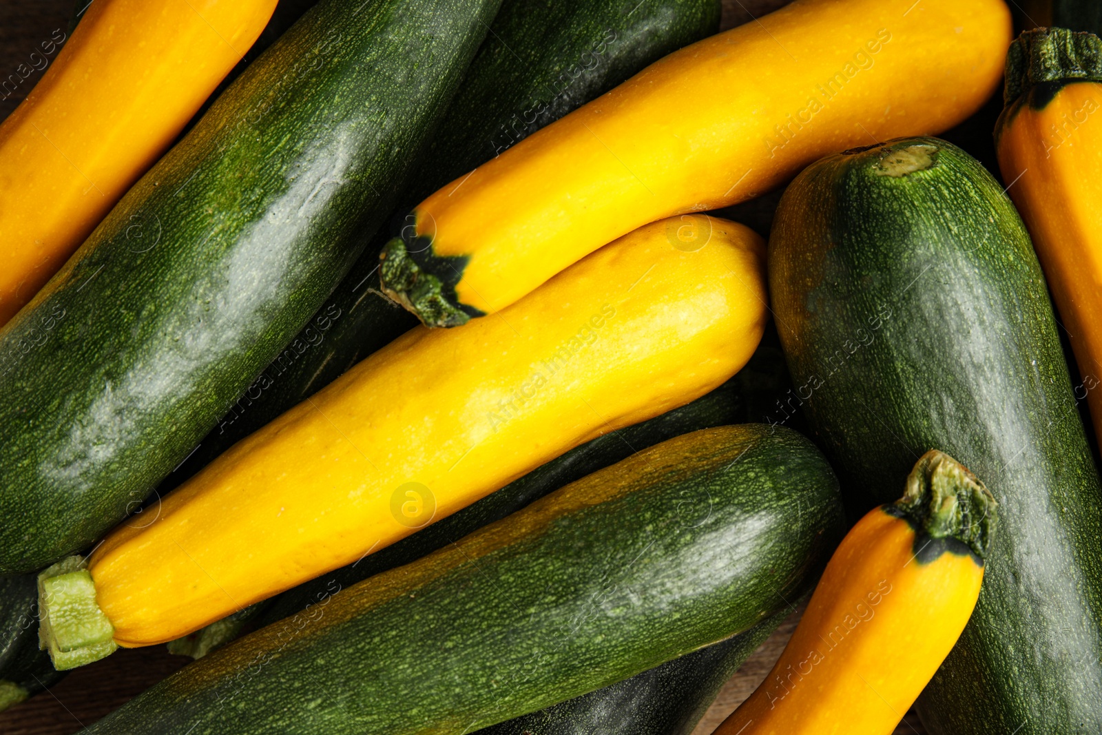 Photo of Top view of fresh ripe zucchini as background, closeup