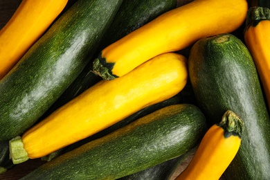 Photo of Top view of fresh ripe zucchini as background, closeup