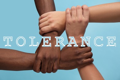 Image of Tolerance, support and cooperation concept. Men of different races joining hands together on light blue background, closeup