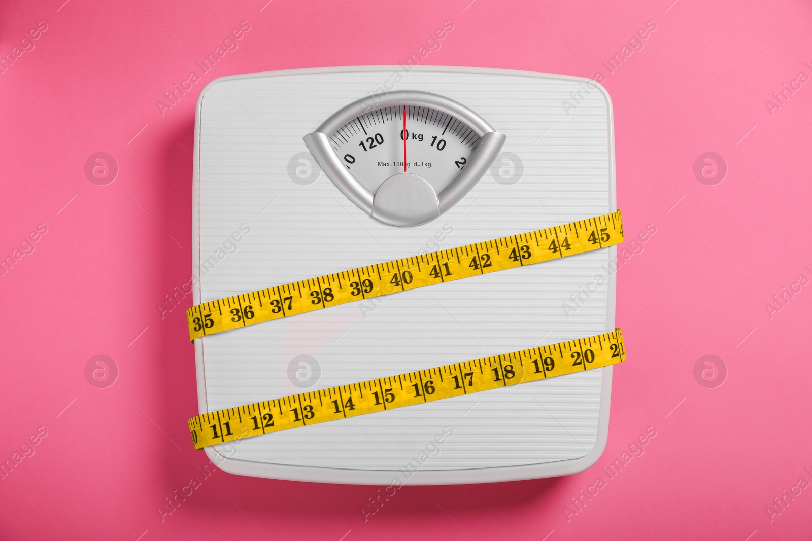 Photo of Weight loss concept. Scales and measuring tape on pink background, top view