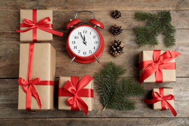 Flat lay composition with Christmas gifts and alarm clock on wooden table. Boxing day