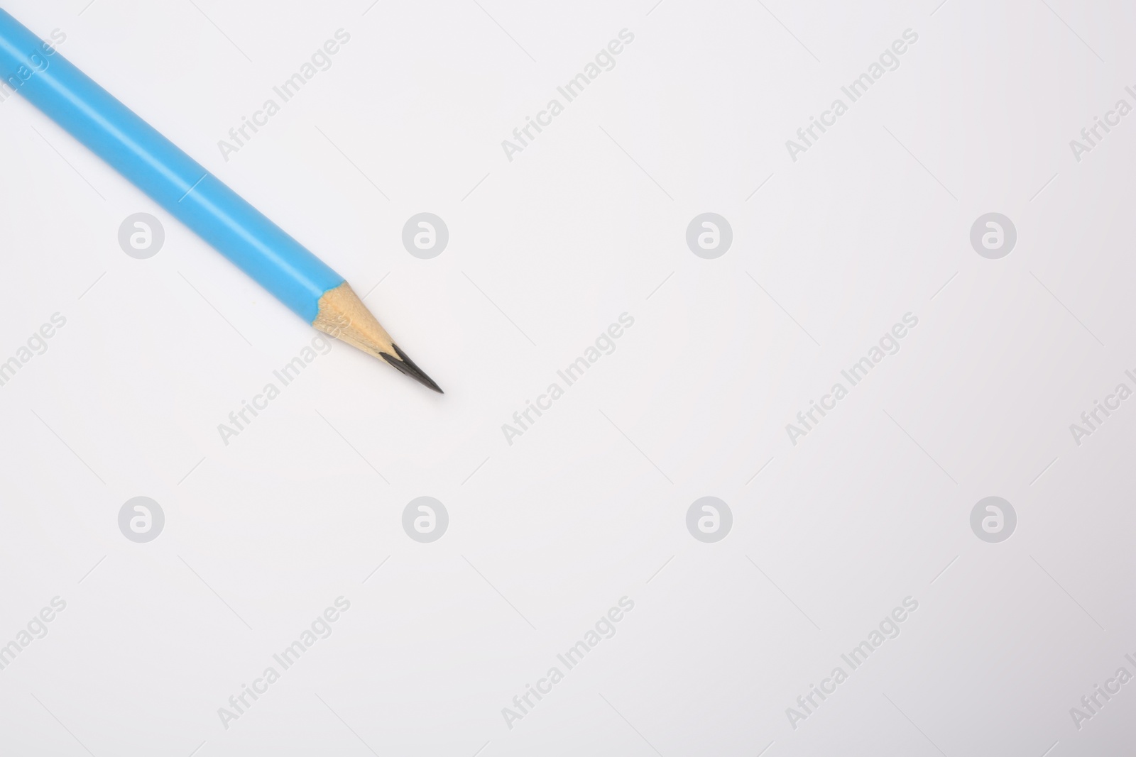 Photo of Sharp graphite pencil on white background, top view. Space for text