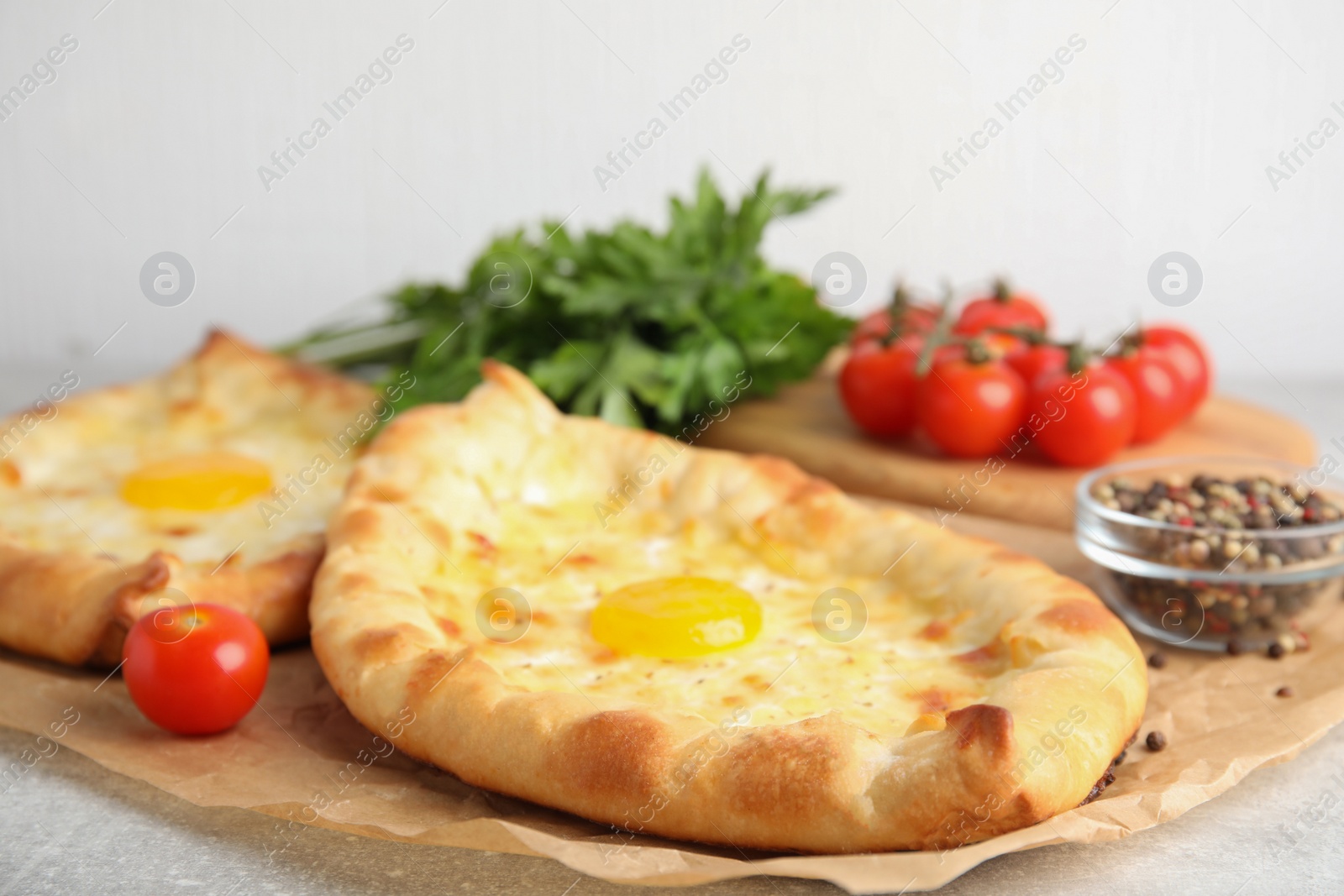 Photo of Fresh delicious Adjarian khachapuris served on grey table