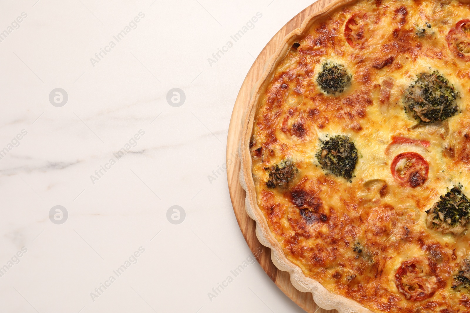 Photo of Delicious homemade vegetable quiche on white marble table, top view. Space for text
