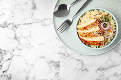 Photo of Delicious chicken risotto served on white marble table, top view. Space for text