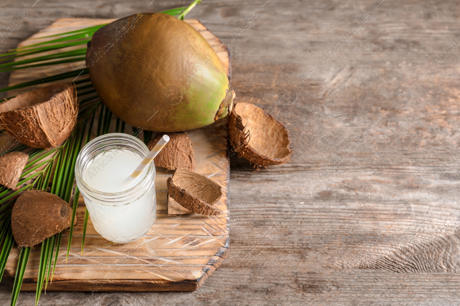 Photo of Composition with fresh green coconut and jar of milk on wooden table