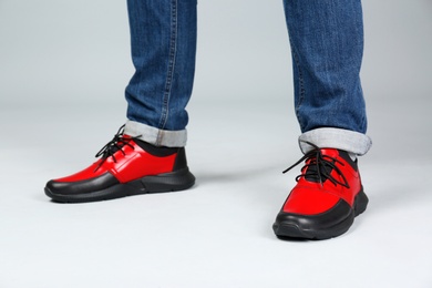 Photo of Man in stylish sport shoes on light background