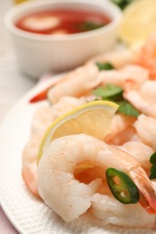 Tasty boiled shrimps with cocktail sauce, chili and parsley on table, closeup