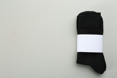 Photo of Pair of black cotton socks on grey background, top view. Space for text