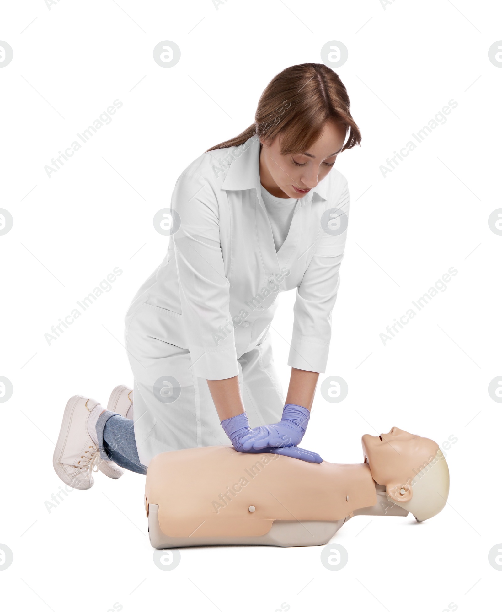 Photo of Doctor in uniform practicing first aid on mannequin against white background