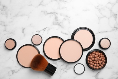 Photo of Flat lay composition with various makeup face powders on marble background. Space for text