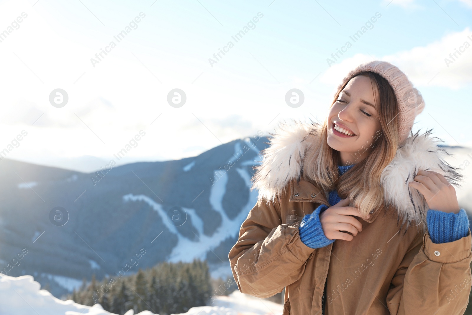 Photo of Happy young woman spending winter vacation in mountains. Space for text