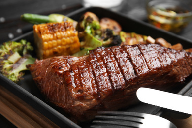 Photo of Delicious grilled beef tenderloin served on table, closeup