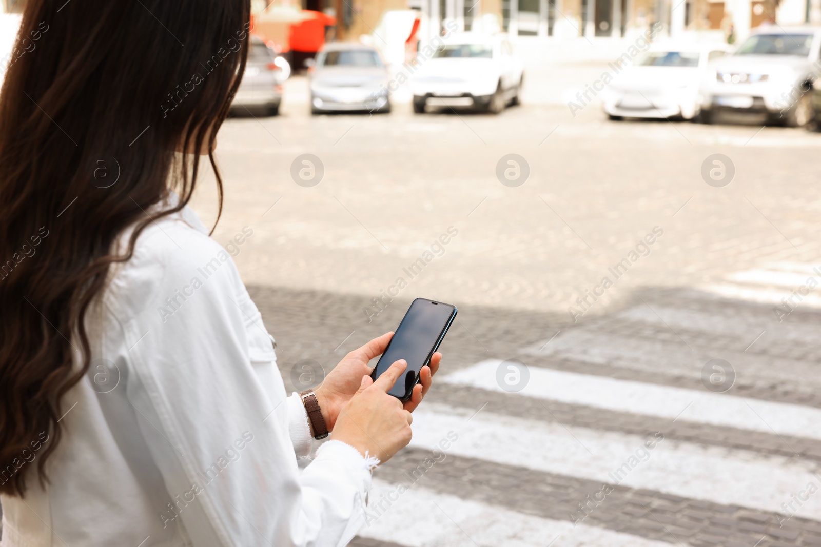 Photo of Woman with smartphone on pedestrian crossing, closeup