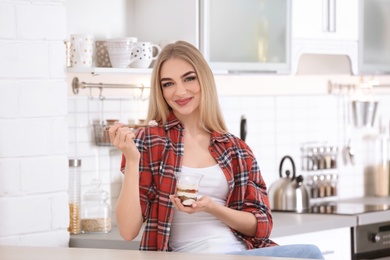 Photo of Young woman with yogurt in kitchen