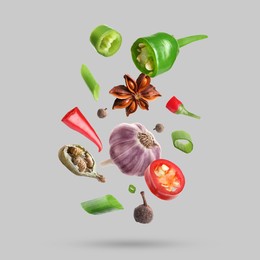 Image of Different spices falling on light grey background