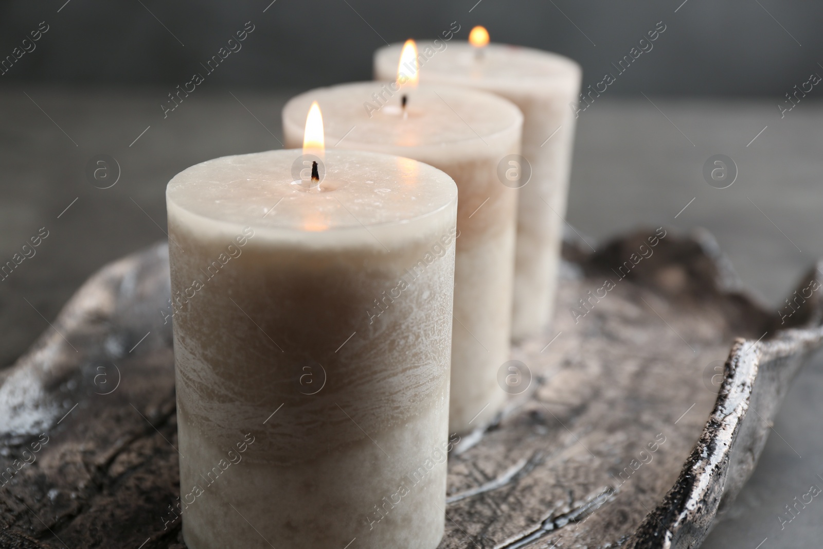 Photo of Tray with three burning candles on table